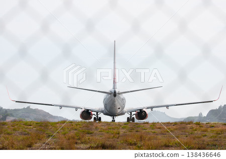 A huge passenger plane pulls onto the runway of Thailand airport, a view through the fence A huge passenger plane pulls onto the runway of Thailand airport, a view through the fence 138436646