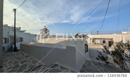 The exterior of a white church half buried underground, built along a cobblestone slope The exterior of a white church half buried underground, built along a cobblestone slope 138436768