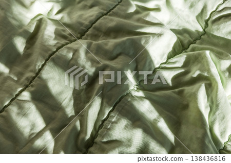 Close-up of a soft green comforter with quilted stitching Close-up of a soft green comforter with quilted stitching 138436816