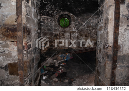 Abandoned Brick Dungeon With Circular Green-Tinted Window And Debris Stacked Floor In Dark Rustic Texture Showing Decay And Neglect Over Time 138436852