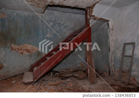 Dilapidated Blue Basement With Red Wooden Staircase Leading Up Amidst Peeling Paint And Debris In Abandoned Building Interior Scene 138436853
