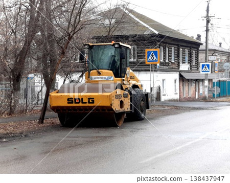 Petropavlovsk, Kazakstan - November 23, 2025: Blue road roller parked on street near trees Petropavlovsk, Kazakstan - November 23, 2025: Blue road roller parked on street near trees 138437947