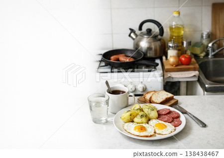 Plate with eggs, potatoes and sausage on the kitchen counter. Space for text. 138438467