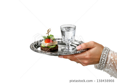 A hand holds a tray with canapes and a glass of water. Space for text. A hand holds a tray with canapes and a glass of water. Space for text. 138438908