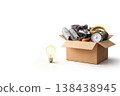 Cardboard box with things and a light bulb on a light background. Space for text. 138438945