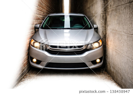 A silver car in a very narrow passage between the walls. Space for text. 138438947