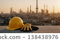 Safety helmet and gloves overlooking industrial refinery at sunset 138438976