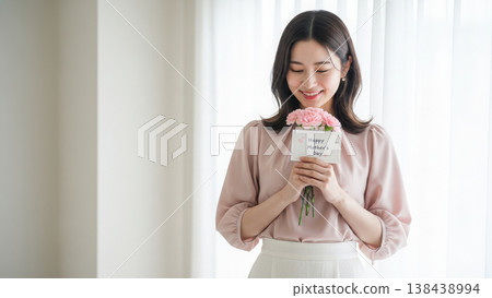 一對母女坐在客廳沙發上，一邊看著各自的智慧型手機，一邊微笑著享受彼此的陪伴。 138438994