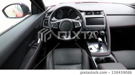 Look from drivers position on dashboard, steering wheel and leather stitched seat inside car Look from drivers position on dashboard, steering wheel and leather stitched seat inside car 138439086