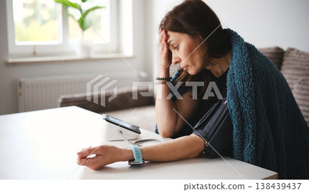 Woman Feeling Unwell At Home Turns On A Digital Blood Pressure Monitor Woman Feeling Unwell At Home Turns On A Digital Blood Pressure Monitor 138439437
