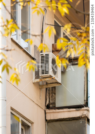 air conditioner is installed on facade of the building. air conditioner compressor is on wall. air conditioner is installed on facade of the building. air conditioner compressor is on wall. 138439464