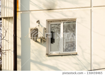 air conditioner is installed on facade of the building. air conditioner compressor is on wall. air conditioner is installed on facade of the building. air conditioner compressor is on wall. 138439465