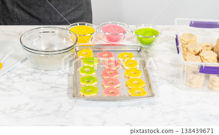 A baking tray filled with colorful flower-shaped cookies coated in yellow, pink, and green sugar, part of the Easter Cookie Sandwich with Raspberry Buttercream recipe. A baking tray filled with colorful flower-shaped cookies coated in yellow, pink, and green sugar, part of the Easter Cookie Sandwich with Raspberry Buttercream recipe. 138439671