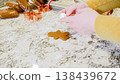 Using various festive cookie cutters, we're cutting out charming gingerbread cookies from the rolled dough on the sleek marble counter, bringing holiday cheer to the modern kitchen. 138439672