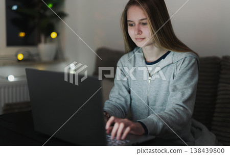 Teenage Girl Sitting In A Cozy Room At Night Using A Laptop And Surfing On The Internet Teenage Girl Sitting In A Cozy Room At Night Using A Laptop And Surfing On The Internet 138439800