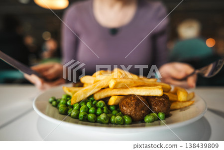 Girl Eating French Fries With Vegetables And Grilled Meatballs In A Cafe 138439809