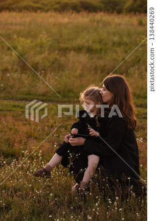 Gentle Mother Guides Young Girl Through Blooming Wildflowers In Bright Meadow Setting Gentle Mother Guides Young Girl Through Blooming Wildflowers In Bright Meadow Setting 138440269