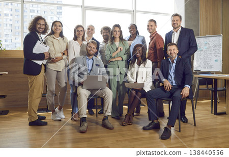 Group of confident business people standing in office looking at the camera and smiling. Group of confident business people standing in office looking at the camera and smiling. 138440556