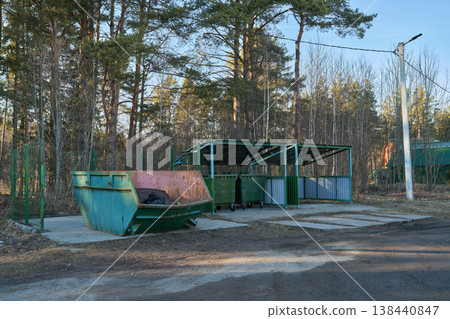 Snow Patches Cast Shadows On Asphalt Station. Municipal Waste Containers Beside Forest On Winter Morning Snow Patches Cast Shadows On Asphalt Station. Municipal Waste Containers Beside Forest On Winter Morning 138440847
