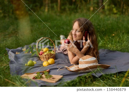 Woman positioning various fruits on blanket in natural light 138440879