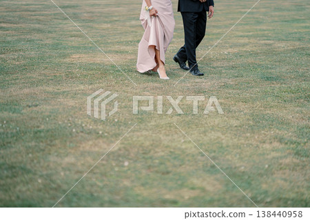 Bride And Groom Walking On Lawn Bride And Groom Walking On Lawn 138440958