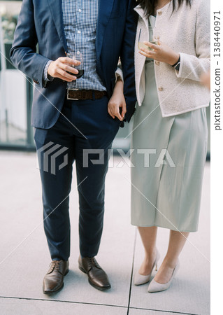 Chic Duo Enjoying Drinks Outdoors During Evening In Town Chic Duo Enjoying Drinks Outdoors During Evening In Town 138440971