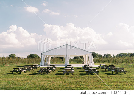 Relaxed Outdoor Venue Featuring Picnic Tables Under Sunny Sky 138441363