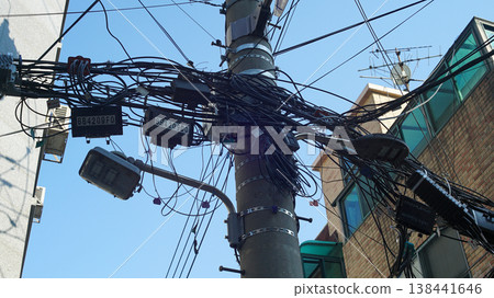 Electric pole with tangled wires in a residential area 138441646