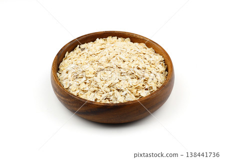 Oat flakes uncooked in a brown bowl on white background.  Healthy food for breakfast 138441736