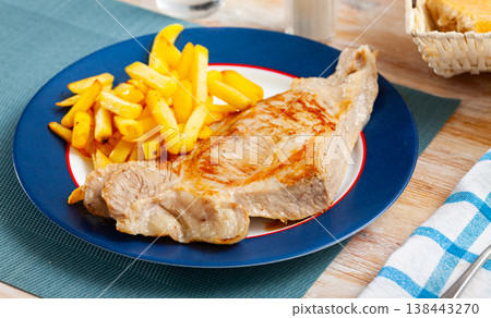 Fried pork tenderloin with potatoes, served with greens 138443270