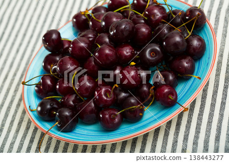 Image of fresh tasty red cherries on blue plate Image of fresh tasty red cherries on blue plate 138443277