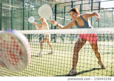 Young woman playing Padel Tennis in open-air tennis court Young woman playing Padel Tennis in open-air tennis court 138443299