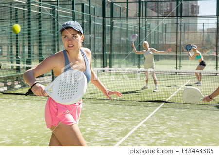 Young woman looking back after the ball while playing Padel Tennis in tennis court 138443385