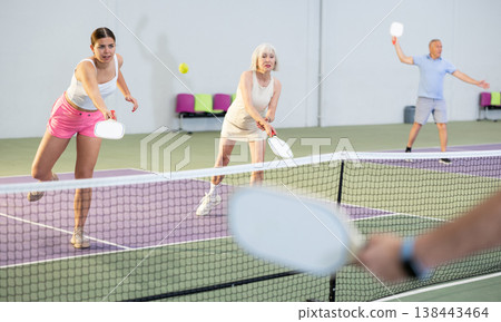 Womens playing pickleball tennis on the pickleball court indoors 138443464