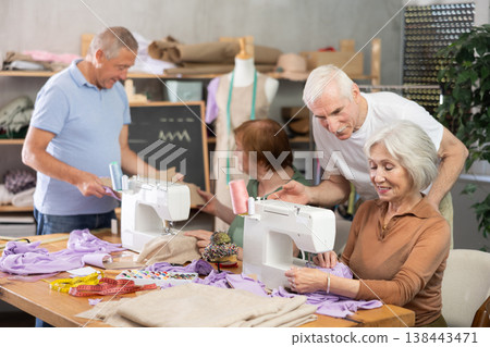 Some people communicate and discuss pattern, while others sew using sewing machine at lesson Some people communicate and discuss pattern, while others sew using sewing machine at lesson 138443471