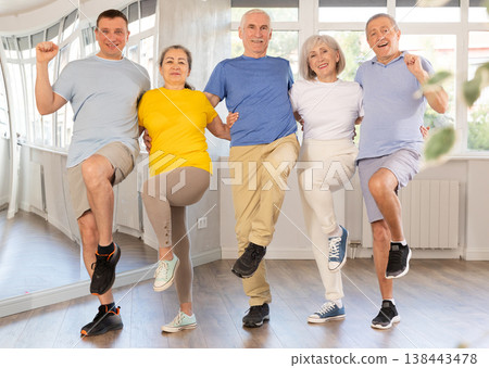 Positive adults forming line while rehearsing celtic dances in dance studio 138443478