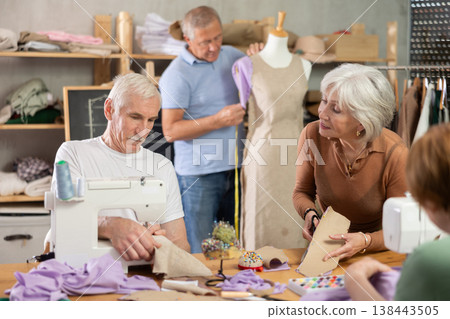Some people talking, while others sew, work with mannequin, cut out dress pattern Some people talking, while others sew, work with mannequin, cut out dress pattern 138443505