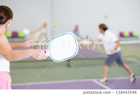 Paddle-shaped racquet for pickleball in hand of female player Paddle-shaped racquet for pickleball in hand of female player 138443546