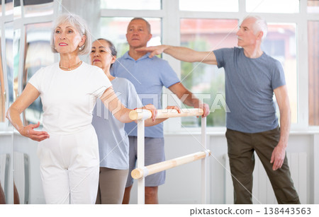 Male choreographer teaches elderly ballet lovers to keep their heads straight during ballet lesson Male choreographer teaches elderly ballet lovers to keep their heads straight during ballet lesson 138443563