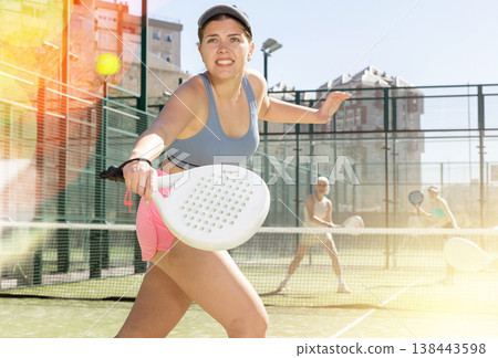 Determined sporty young woman doing her best playing padel in court Determined sporty young woman doing her best playing padel in court 138443598