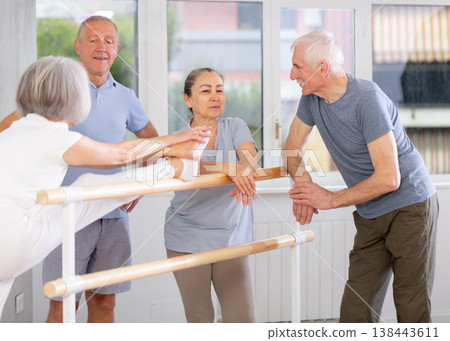 Elderly ballet lovers communicate with each other during break between classes in choreographic studio Elderly ballet lovers communicate with each other during break between classes in choreographic studio 138443611