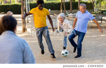 Cheerful group of mixed-race middle-aged and older adult people playing football game outdoors Cheerful group of mixed-race middle-aged and older adult people playing football game outdoors 138443693