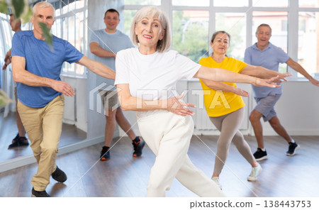 Woman participating in Zumba class for seniors in fitness studio Woman participating in Zumba class for seniors in fitness studio 138443753
