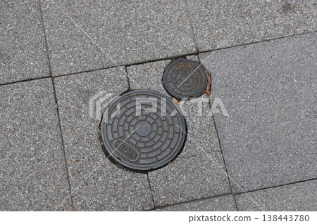 Two manhole covers, one large and one small (sewage). Two manhole covers, one large and one small (sewage). 138443780
