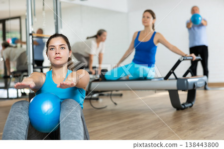 Young woman practicing pilates with ball in fitness hall Young woman practicing pilates with ball in fitness hall 138443800