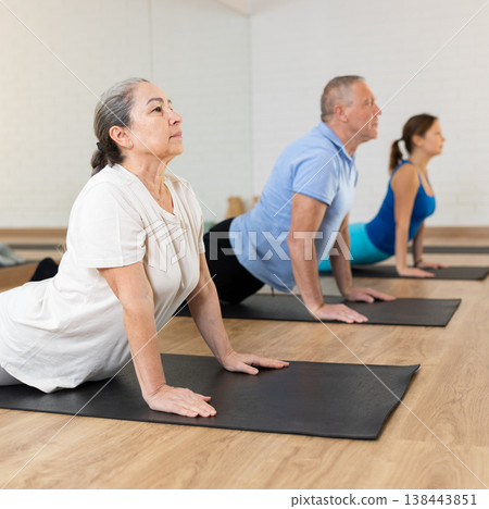 Senior woman doin back bending asana Urdhva Mukha Shvanasana Senior woman doin back bending asana Urdhva Mukha Shvanasana 138443851