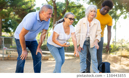 Happy casual diverse pensioners exercising together petanque in a sunny park in Spain Happy casual diverse pensioners exercising together petanque in a sunny park in Spain 138443855