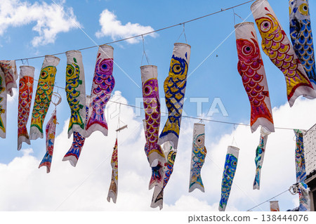 A scene of carp streamers swimming in the blue sky A scene of carp streamers swimming in the blue sky 138444076