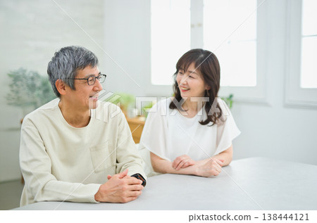 A couple in their 60s having a fun conversation in the living room A couple in their 60s having a fun conversation in the living room 138444121