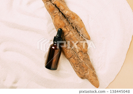 Bottle of cosmetic product serum oil dry tree podium beach white sand. Abstract podium product presentation sandy background Bottle of cosmetic product serum oil dry tree podium beach white sand. Abstract podium product presentation sandy background 138445048